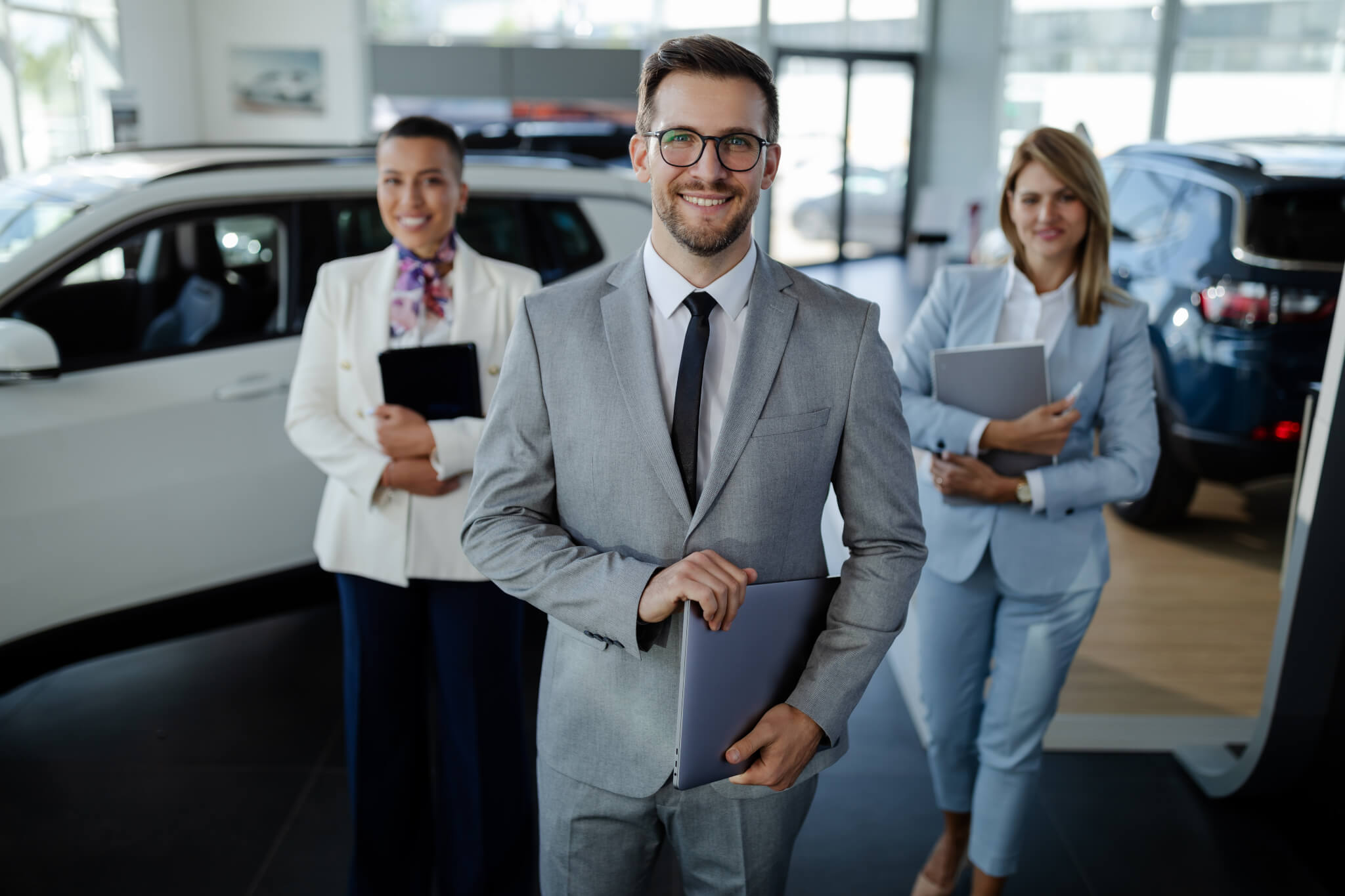 salesteam-in-dealership-three-beautiful-consultants-or-managers-in-elegant-suit-looking-on-camera-.jpg